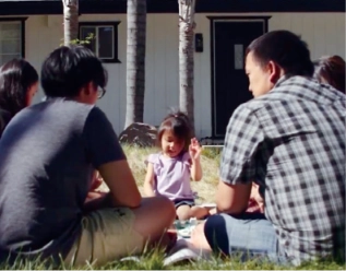 A family gathered outside their first home
